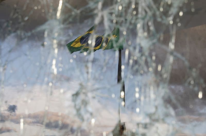 FOTO DE ARCHIVO. Una bandera brasileña ondea detrás de vidrios rotos en el edificio del Supremo Tribunal Federal, luego de los disturbios antidemocráticos, en Brasilia, Brasil