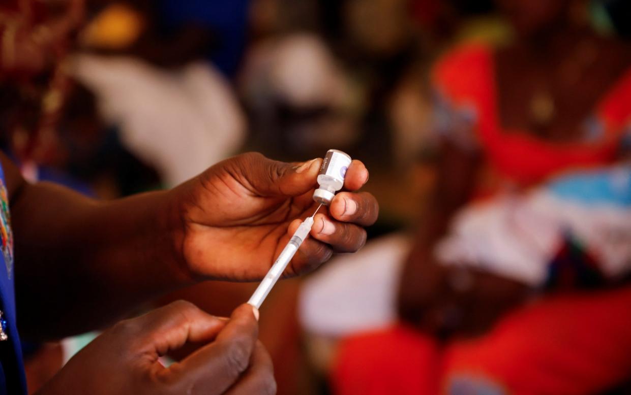 A nurse prepares to administer a malaria vaccine to an infant at the health center in Datcheka, Cameroon