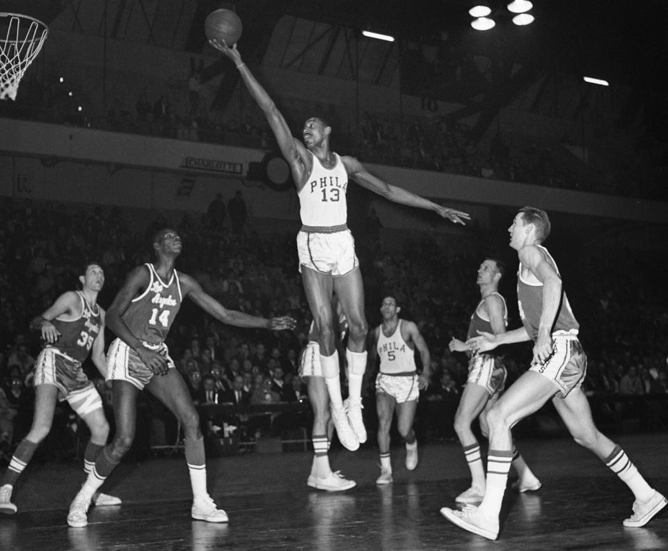 FILE - In this Feb. 28, 1961, file photo, Wilt Chamberlain, of the Philadelphia Warriors, center, stretches for a basket against the Los Angeles Lakers at the Philadelphia Arena in Philadelphia. (AP Photo/Warren M. Winterbottom, File)