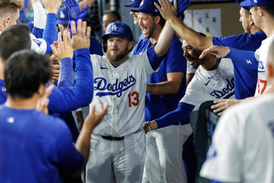 Dodgers high-five Max Muncy in the dugout.