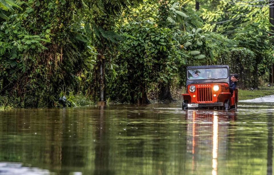 Juan Antonio Molina drives his old jeep through a road flooded in Toa Alta by Hurricane Fiona that hit Puerto Rico.