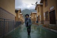 A minority woman stands in between new village houses in Ganluo county, southwest China's Sichuan province on Sept. 10, 2020. China's ruling Communist Party says its initiatives have helped to lift millions of people out of poverty. Yi ethnic minority members were moved out of their mountain villages in China’s southwest and into the newly built town in an anti-poverty initiative. (AP Photo/Andy Wong)
