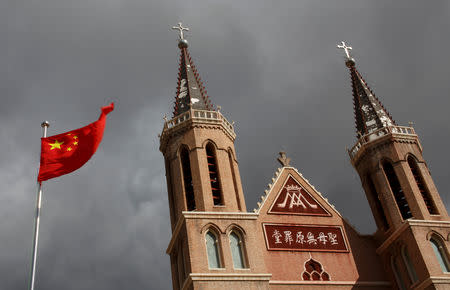 FILE PHOTO: The Chinese national flag flies in front of a Catholic underground church in the village of Huangtugang, Hebei province, China, September 30, 2018. REUTERS/Thomas Peter/File Photo