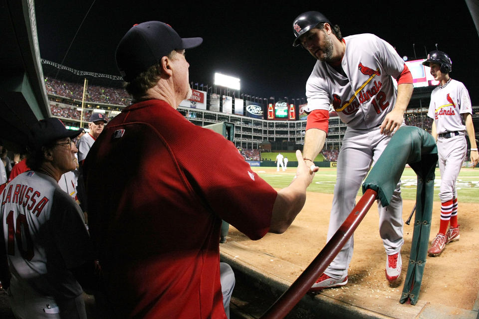 ARLINGTON, TX - OCTOBER 22: Lance Berkman #12 of the St. Louis Cardinals is congratulated by batting coach Mark McGuire after scoring in the fifth inning during Game Three of the MLB World Series against the Texas Rangers at Rangers Ballpark in Arlington on October 22, 2011 in Arlington, Texas. (Photo by Doug Pensinger/Getty Images)