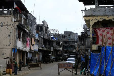 Government soldiers stand guard in front of damaged houses and building in Sultan Omar Dianalan boulevard at Mapandi district in Marawi city, southern Philippines September 13, 2017. REUTERS/Romeo Ranoco