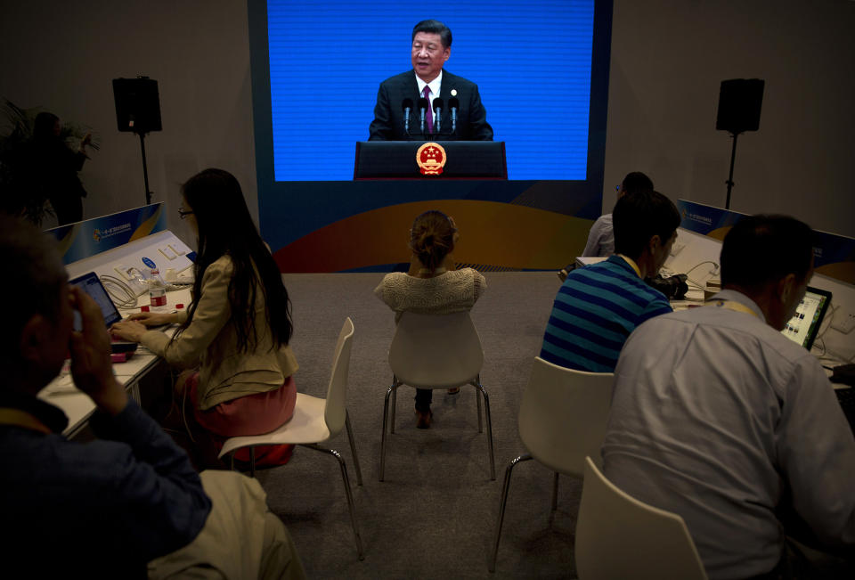 En esta imagen de archivo del 15 de mayo de 2017, periodistas trabajando en computadoras en el Centro Nacional de Convenciones de China mientras el presidente, Xi Jinping, hace una declaración al final del Foro Cinturón y Ruta de la Seda en Beijing. (AP Foto/Mark Schiefelbein, Archivo)