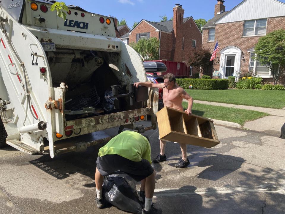 Trash is thrown out in Grosse Point Farms, Mich., Sunday, June 27, 2021. Residents in the Detroit area were cleaning up Sunday after flooding in the area overloaded sewer systems, damaged homes and knocked out power for thousands. (AP Photo/Ed White)