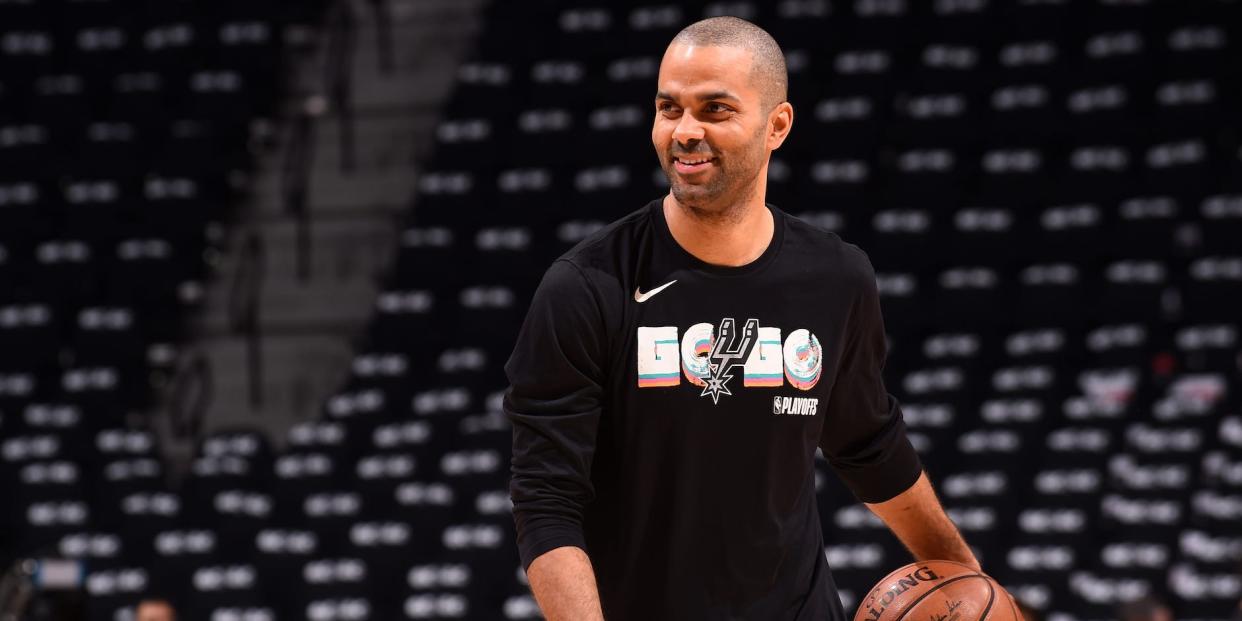 Tony Parker holds a basketball and smiles during warmups before a Spurs game in 2018.