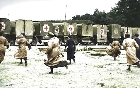 Ambulance drivers run to their vehicles - Credit: Reproduced with the permission of the British Red Cross Museum and Archives