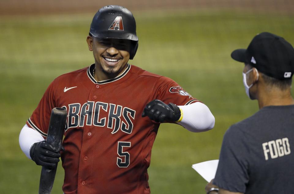 Arizona Diamondbacks' Eduardo Escobar (5) smiles as he celebrates his home run with manager Torey Lovullo, right, during a baseball training camp intrasquad scrimmage Sunday, July 12, 2020, in Phoenix. (AP Photo/Ross D. Franklin)