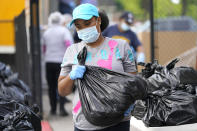 Brandy Oveal, with the Houston Independent School District Nutrition Services, prepares to help distribute bags of food Monday, April 6, 2020, in Houston. HISD relaunched their food distribution efforts throughout the district Monday, with a streamlined process that will implement increased safety measures. (AP Photo/David J. Phillip)