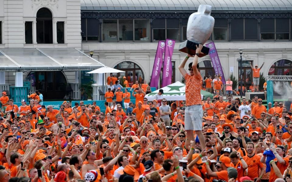 A Netherlands fan holds a giant, homemade trophy aloft - REUTERS