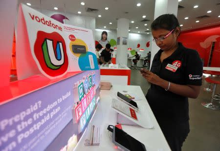 An employee checks a customer’s mobile phone inside a Vodafone store in Kolkata, India, September 26, 2016. REUTERS/Rupak De Chowdhuri