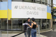 A security guard talks to a women in front of the Ukrainian House alongside the World Economy Forum in Davos, Switzerland, Sunday, May 22, 2022. The annual meeting of the World Economy Forum is taking place in Davos from May. 22 until May. 26, 2020. (AP Photo/Markus Schreiber)