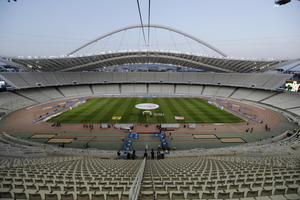 FILE - Players from Greek champion Olympiakos, right, and AEK Athens line up ahead of the Greek Final Cup at the empty Olympic Stadium of Athens, Tuesday, May 17, 2016. Government officials say Monday, Oct. 2, 2023 a new inspection has been ordered at a stadium that hosted the Athens Olympics in 2004 after rust was found along the iconic arched roof, forcing the site to close. The arched roof structures were designed by renowned Spanish architect Santiago Calatrava for the 2004 Athens Olympics. (AP Photo/Thanassis Stavrakis, File)