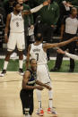 Milwaukee Bucks' Khris Middleton, foreground, reacts during the second half of Game 6 of a second-round NBA basketball playoff series against the Brooklyn Nets, Thursday, June 17, 2021, in Milwaukee. (AP Photo/Jeffrey Phelps)