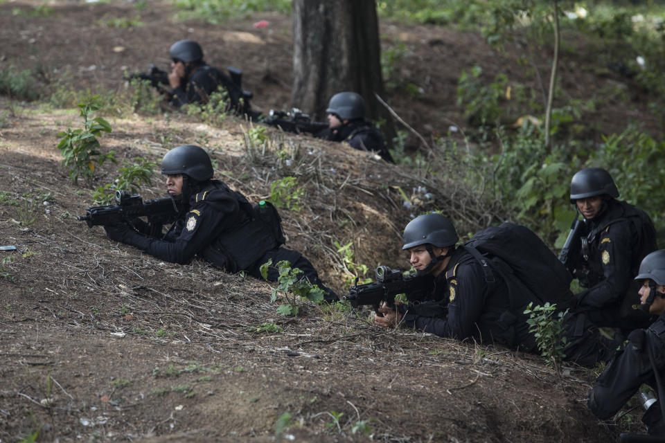 Special task force police take position outside the Pavon Rehabilitation Model Farm after a shooting inside the jail in Fraijanes, Guatemala, Tuesday, May 7, 2019. At least three people were killed and 10 people were wounded in the shooting, authorities said. (AP Photo/Oliver De Ros)