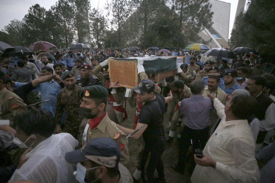 Soldiers carry the national flag-wrapped casket of Pakistani nuclear scientist Abdul Qadeer Khan during his funeral prayer, in Islamabad, Pakistan, Sunday, Oct. 10, 2021. Khan, a controversial figure known as the father of Pakistan's nuclear bomb, died Sunday of COVID-19 following a lengthy illness, his family said. He was 85. (AP Photo/Anjum Naveed)