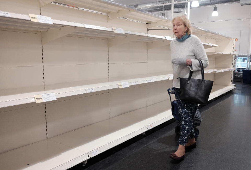 A lady looking at empty shelves in a Sainsbury's store in London, as the death toll from coronavirus in the UK reached 71 people.