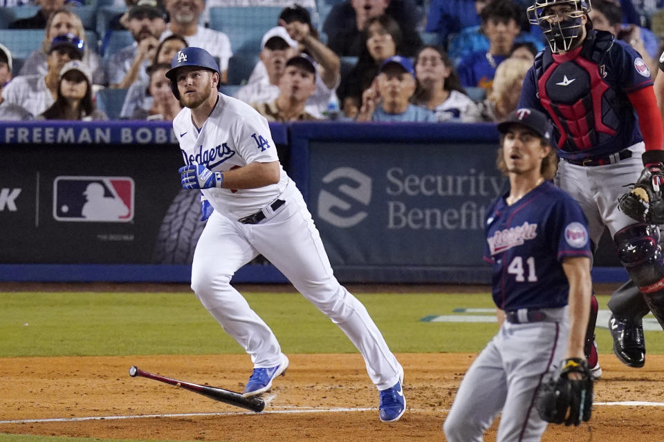 Los Angeles Dodgers' Max Muncy, left, heads to first as he hits a solo home run while Minnesota Twins starting pitcher Joe Ryan, center, and catcher Sandy Leon watch during the third inning of a baseball game Tuesday, Aug. 9, 2022, in Los Angeles. (AP Photo/Mark J. Terrill)