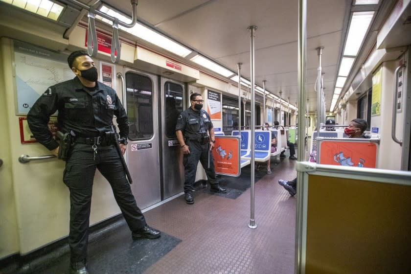 HOLLYWOOD, CA - JUNE 25: LAPD officers E. Rosales, left, and D. Castro, patrol the Metro Red Line at the Hollywood/Highland Metro Station Thursday, June 25, 2020 in Hollywood, CA. The Metro Board of Directors held a meeting Thursday where the agenda included the consideration of appointing a committee to develop plans for replacing armed transit safety officers with ``smarter and more effective methods of providing public safety.'' Metro security is staffed by multiple agencies, including the L.A. County Sheriff's Department and L.A. and Long Beach police departments, transit security guards and contract security workers. (Allen J. Schaben / Los Angeles Times)