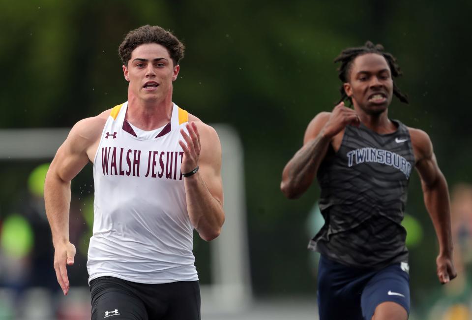 Jonathan Keough of Walsh Jesuit, left, leads Brandon Moore of Twinsburg in the boys 100 meter dash during the Division I district track meet at Nordonia High School, Friday, May 17, 2024, in Macedonia, Ohio.