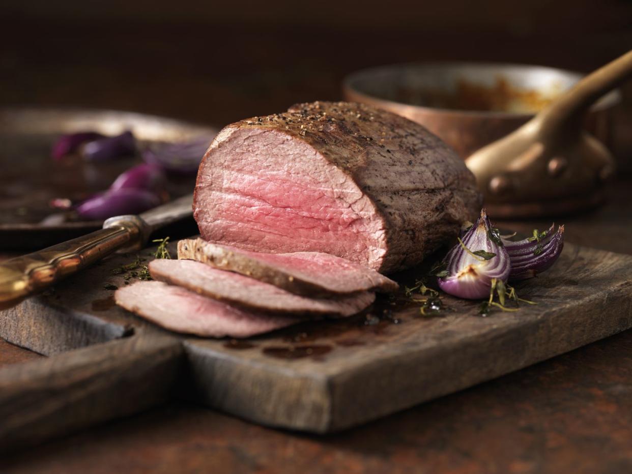 Christmas dinner. Chateaubriand steak cooked with a thick cut from the tenderloin filet, rare medium served with roasted onions, pepper and herbs