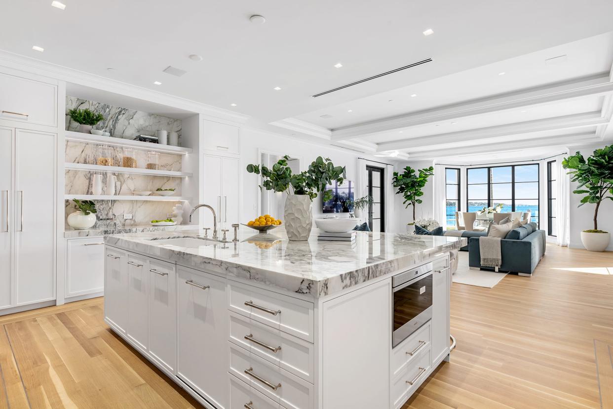 The main kitchen — one of two in the house — has a center work island with pull-up seating on the side facing the family room and breakfast area at 10 Tarpon Island in Palm Beach.