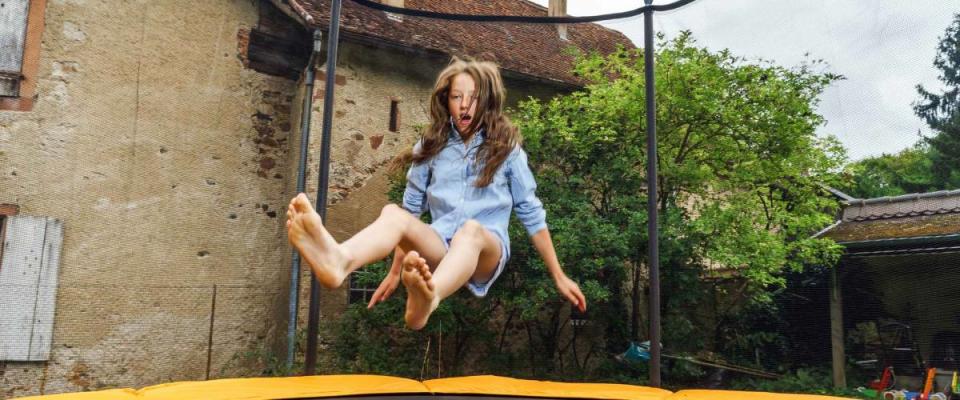 Teenage girl bouncing on trampoline, childhood concept