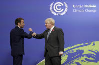 British Prime Minister Boris Johnson, left, greets French President Emmanuel Macron, at the COP26 U.N. Climate Summit in Glasgow, Scotland, Monday, Nov. 1, 2021. The U.N. climate summit in Glasgow gathers leaders from around the world, in Scotland's biggest city, to lay out their vision for addressing the common challenge of global warming. (Christopher Furlong/Pool via AP)