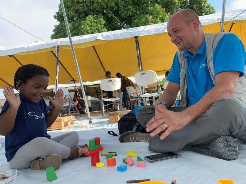 Laurent Duvillier, regional chief of communication for UNICEF in Latin America and the Caribbean, plays near the airport with Claudia, who was born in Chile to Haitian refugees. Claudia is among the children picked up at the U.S.-Mexico border and sent back to Haiti despite never living there and not speaking Creole, the native language.