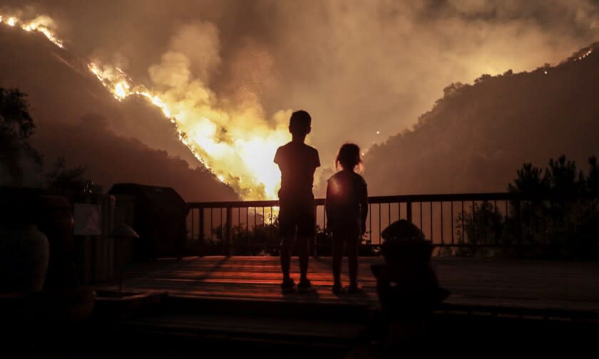 Monrovia, CA, September 15, 2020 - Iris, 4, and Castle Snider, 8, look on as flames engulf the hillsides behind their backyard as the Bobcat Fire burns near homes on Oakglade Dr. (Robert Gauthier/ Los Angeles Times)