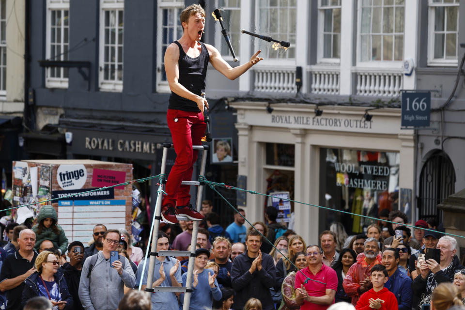 EDINBURGH, SCOTLAND - AUGUST 22: A street entertainer juggles on Edinburgh's Royal Mile during the final full week of the city's Festival Fringe on August 22, 2023 in Edinburgh, Scotland. Thousands of performers from across the world are in the Scottish Capital for the world's biggest arts festival, Edinburgh Festival Fringe hosts thousands of shows is now marking its 76th year.  (Photo by Jeff J Mitchell/Getty Images)