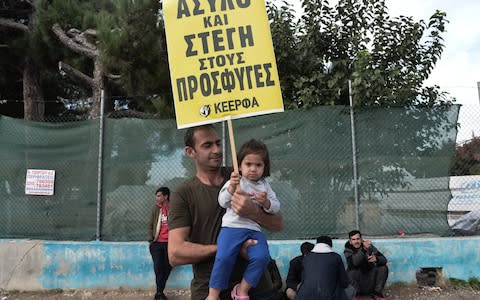 A child shows support for migrants in refugee camp near Thessaloniki