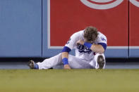 Los Angeles Dodgers second baseman Gavin Lux falls sits on the ground after missing a catch on a ball hit for an RBI triple by San Diego Padres' Wil Myers and running into the wall during the sixth inning of a baseball game Wednesday, Sept. 29, 2021, in Los Angeles. (AP Photo/Mark J. Terrill)