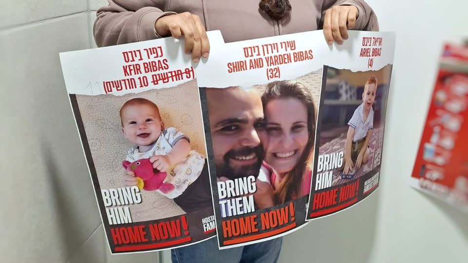 Ofri Bibas Levy holds posters of his family, including that of his brother, Yarden Bibas, taken hostage in Gaza.  - Ofri Levi-Bibas
