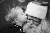 <p>During the Christmas retail season, a young white boy kisses a Black Santa Claus on the cheek in an unidentified department store.</p>