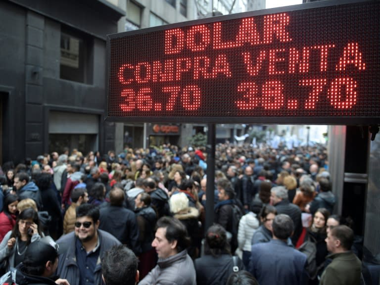 Demonstrators protesting against the government's economic policies pass by a currency exchange office in Buenos Aires, on September 3, 2018