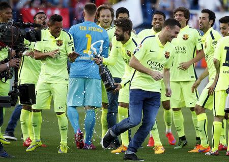 Barcelona players celebrate after winning the Spanish first division title following their soccer match against Atletico Madrid at at Vicente Calderon stadium in Madrid, Spain, May 17, 2015. REUTER/Juan Medina