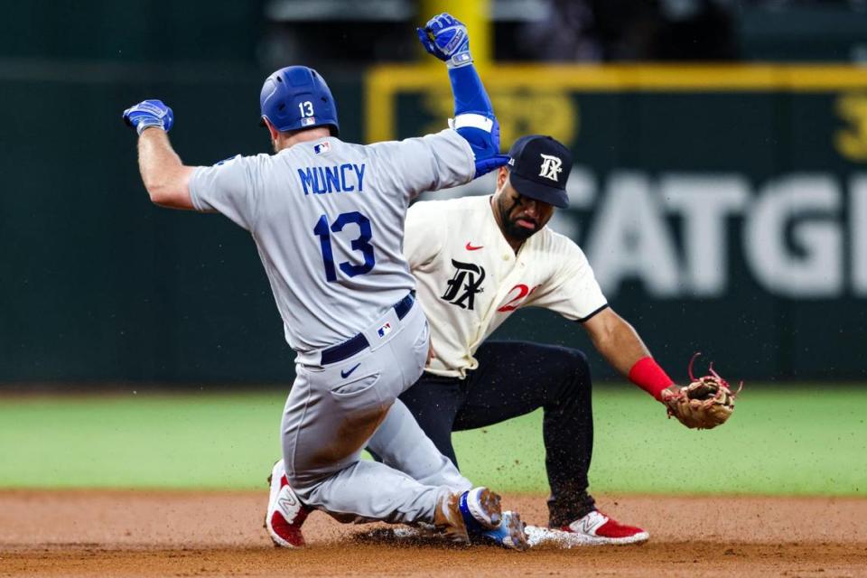 Los Angeles Dodgers infielder Max Muncy (13) slides to second base before Texas Rangers infielder Marcus Semien (2) tags him in the second inning of a regular season match up against the Los Angeles Dodgers at Globe Life Field in Arlington, Texas on Saturday, July 22, 2023. The Rangers gave up 18 hits and lost 16-3.