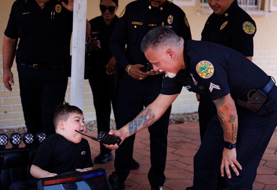 Franco Bernal, 6, battling childhood Leukemia, talks into officer Michael Vega’s radio during his Wish Reveal on Thursday, July 18, 2024, with Make-A-Wish and City of Miami Police in Miami. Bernal loves the police, so his Make-A-Wish to go to Disney World was announced by a parade with both Make-A-Wish and City of Miami Police.