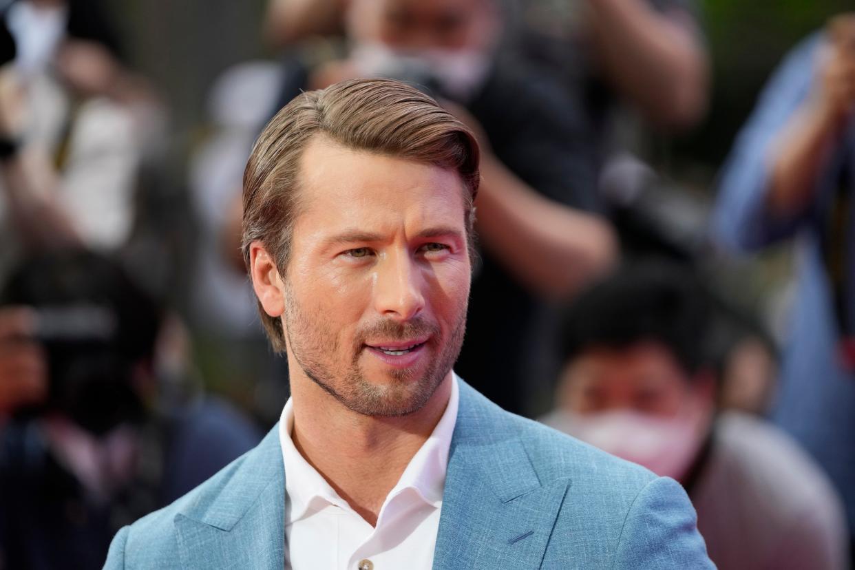 Glen Powell says he strives to accurately represent the military experience in his real-life roles, such as his portrayal of U.S. Navy aviator Tom Hudner in the upcoming film "Devotion." Hudner received the Medal of Honor for his actions during the Korean War. The film will be widely released on Nov. 23.