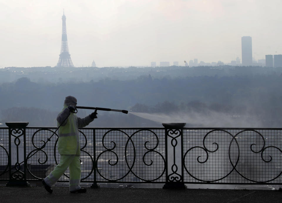 A worker wearing protective gears sprays disinfectant as a precautionary measure against COVID-19 during a nationwide confinement to counter the virus, in Suresnes, outside Paris, Tuesday, March 31, 2020. The new coronavirus causes mild or moderate symptoms for most people, but for some, especially older adults and people with existing health problems, it can cause more severe illness or death. (AP Photo/Christophe Ena)