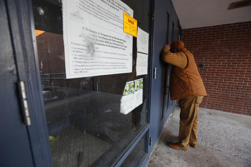 In this Feb. 4, 2019, photo, Steven Harris, a grandfather and former city council member, looks inside the abandoned John C. Clark Elementary and Middle School in Hartford, Conn. The school was closed in 2015 after toxic PCBs were found during a renovation. It is one of several Hartford public schools built during the era when PCBs were commonly used in school construction in caulk, floor adhesive and certain types of fluorescent light ballasts. (AP Photo/Martha Irvine)