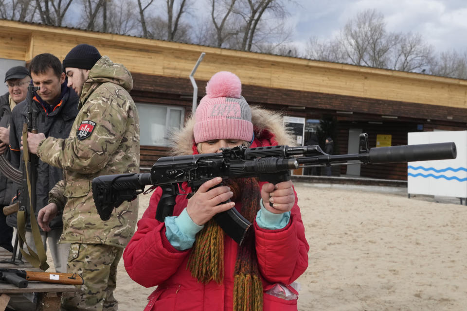 A woman holds a Kalashnikov assault rifle during a training of members of a Ukrainian far-right group train, in Kyiv, Ukraine, Sunday, Feb. 20, 2022. Russia extended military drills near Ukraine's northern borders Sunday amid increased fears that two days of sustained shelling along the contact line between soldiers and Russa-backed separatists in eastern Ukraine could spark an invasion. (AP Photo/Efrem Lukatsky)