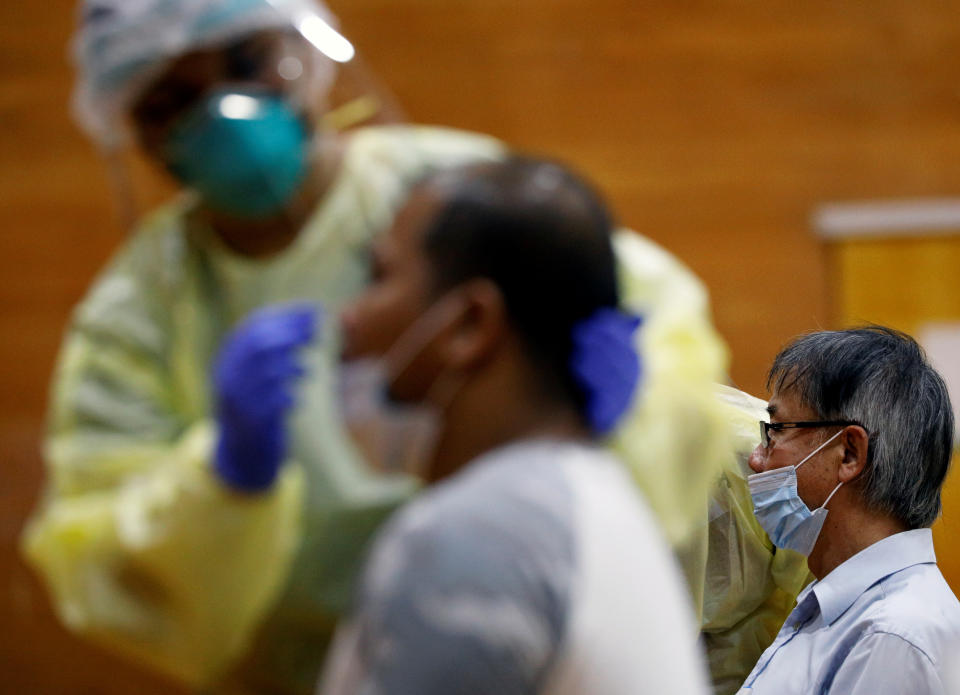 Essential workers have their noses swabbed before returning to the workforce at a regional screening center, amid the coronavirus disease (COVID-19) outbreak in Singapore June 10, 2020.   REUTERS/Edgar Su
