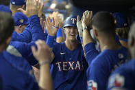 Texas Rangers teammates greet Josh Jung, center, in the dugout after his three-run home off Tampa Bay Rays starter Ryan Pepiot during the first inning of a baseball game Monday, April 1, 2024, in St. Petersburg, Fla. (AP Photo/Steve Nesius)