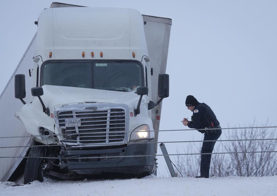 West Des Moines police Officer Barry Graham checks on a damaged truck after an accident on Thursday that blocked the eastbound lanes of Interstate 80 just west of the Jordan Creek exit.