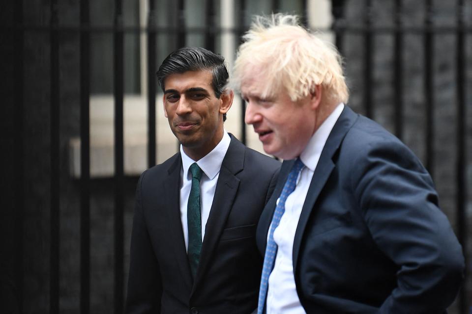 Britain's Prime Minister Boris Johnson (R) stands with Britain's Chancellor of the Exchequer Rishi Sunak during a meeting with Small Business Saturday entrepreneurs in Downing Street in central London on December 1, 2021. (Photo by Daniel LEAL / AFP) (Photo by DANIEL LEAL/AFP via Getty Images)