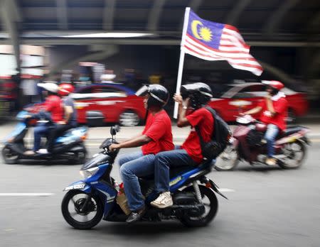 "Red Shirt" demonstrators on motorcycles gather for a rally to celebrate Malaysia Day and to counter a massive protest held over two days last month that called for Prime Minister Najib Razak's resignation over a graft scandal, in Malaysia's capital city of Kuala Lumpur September 16, 2015. REUTERS/Olivia Harris